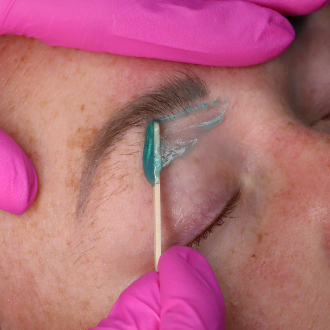 Eyebrow wax using lagoon wax and facial waxing spatulas.