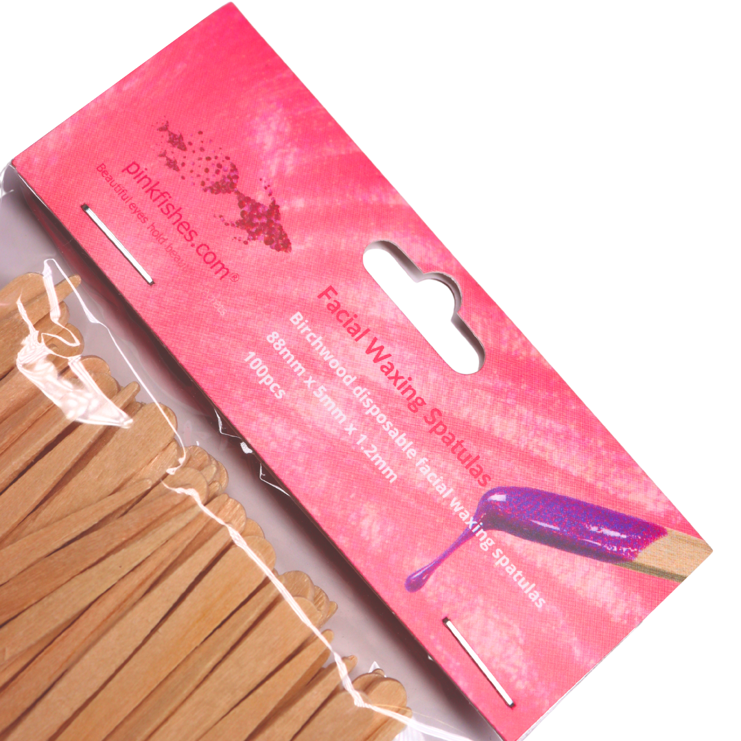 Pink packaging of facial waxing spatulas with wooden spatulas on a white background