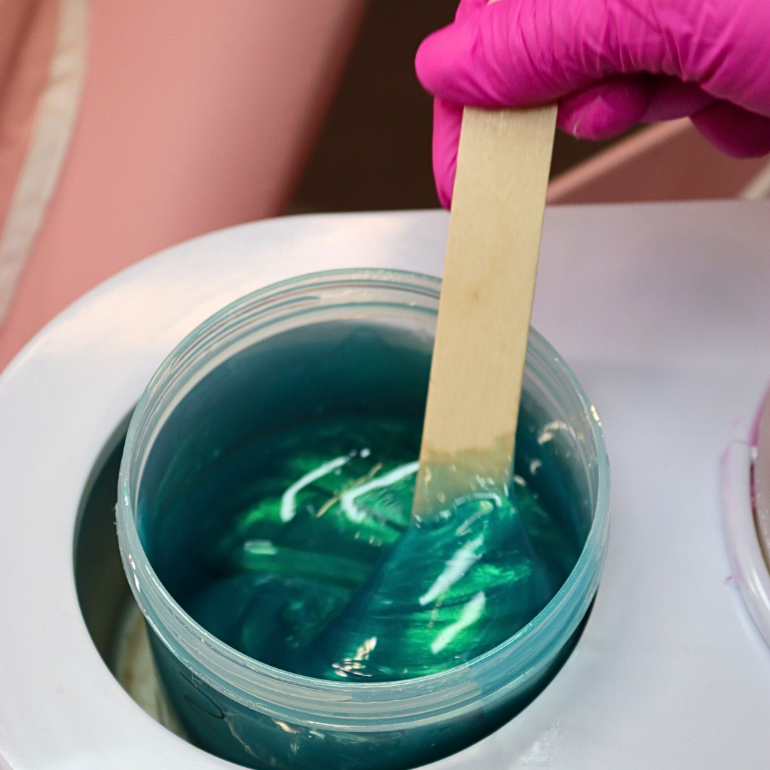 Pinkfishes Lagoon Wax being stirred with a waxing spatula.