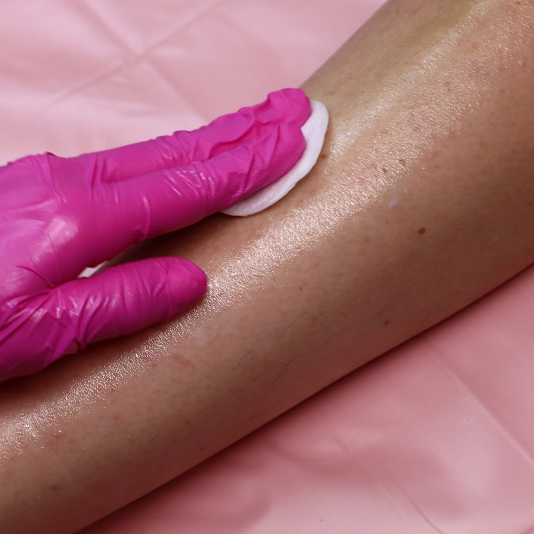 Pre & After Wax Oil being applied to the leg from a cotton pad. 